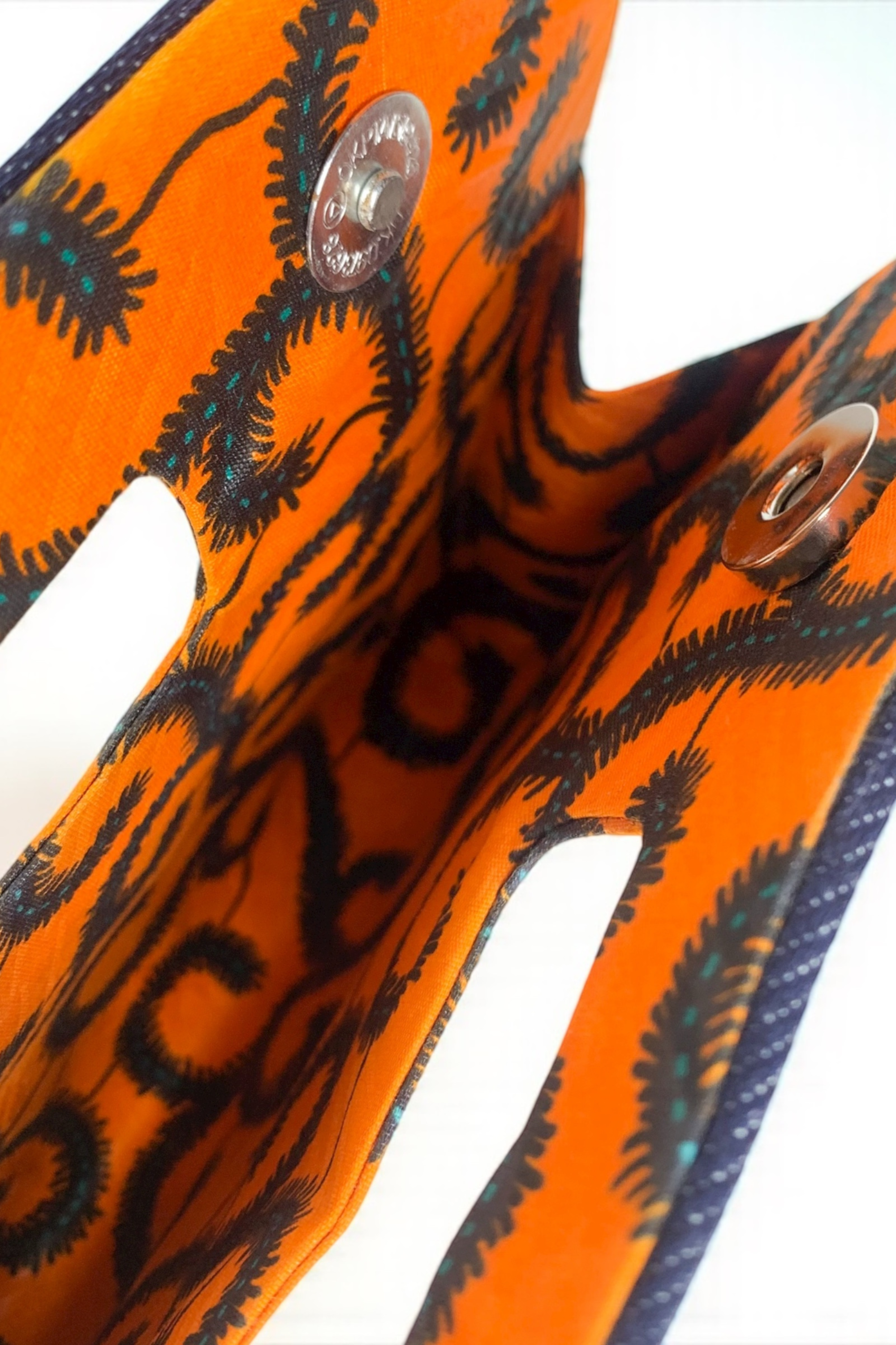 Pochette DITA en wax africain orange, accessoire artisanal élégant Makomie.