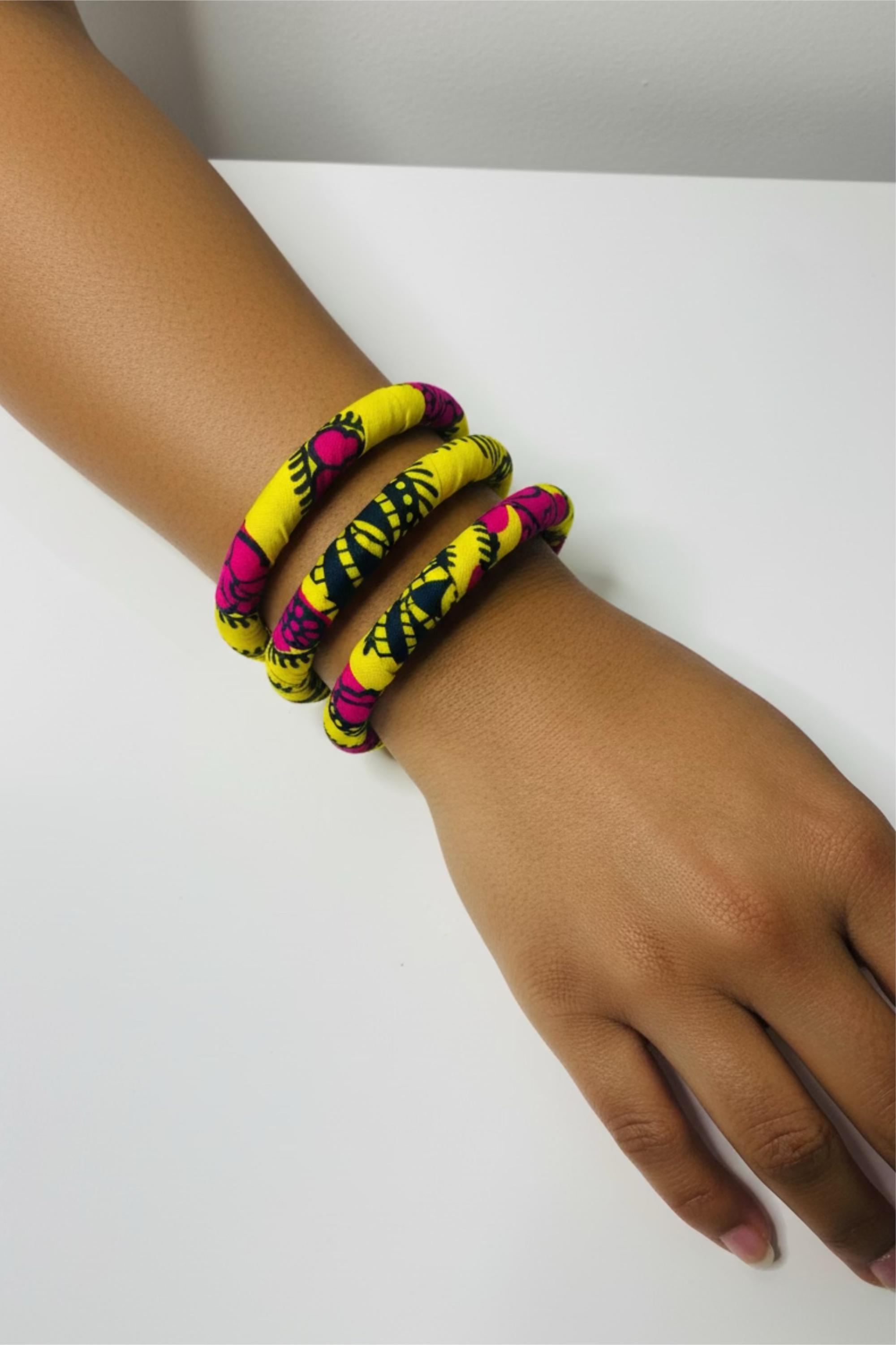 Lot de trois bracelets TIYA en tissu wax africain jaune et rose, présentés ensemble, accessoires de mode artisanaux