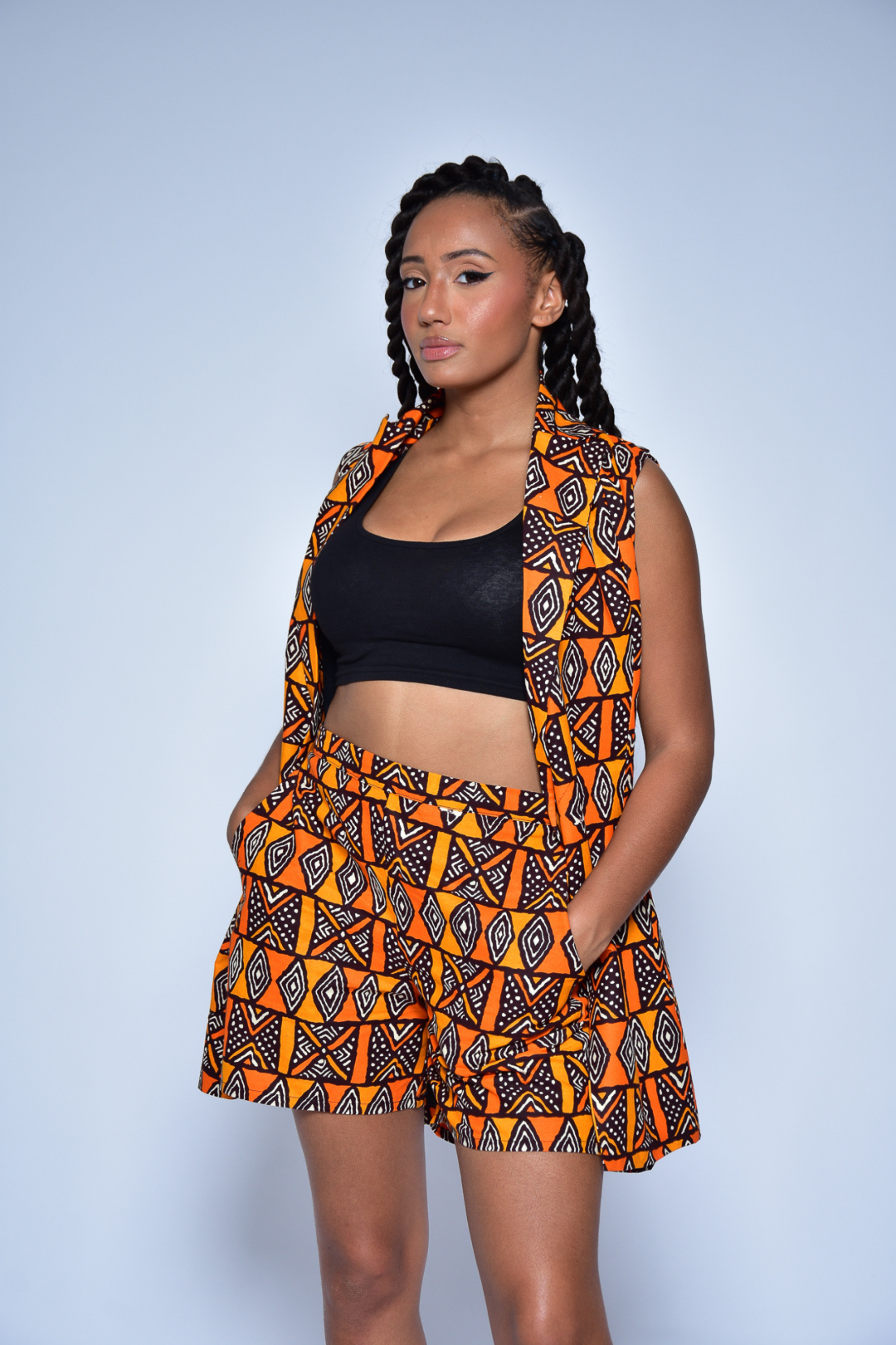 Veste sans manches EST en wax géométrique orange – vue de côté, création artisanale Makomie